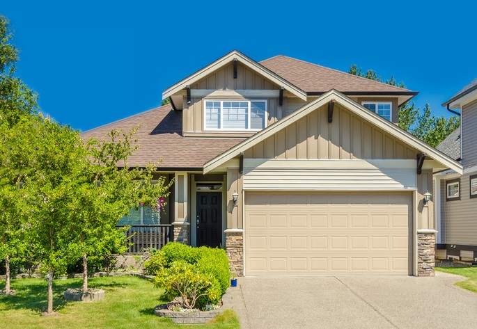 Two-story suburban home with beige siding, garage, and front yard